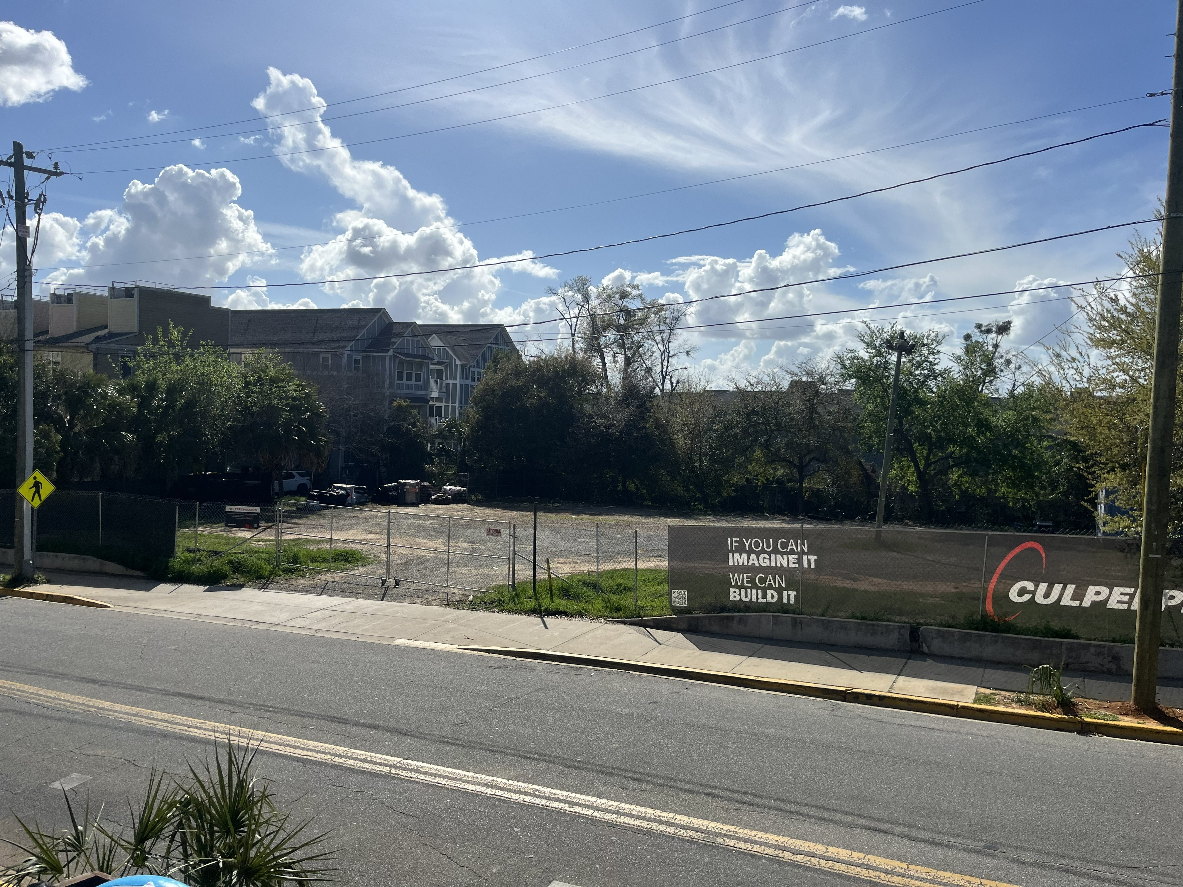 Real photo of the empty Pensacola Street lot with Culpepper Construction signage