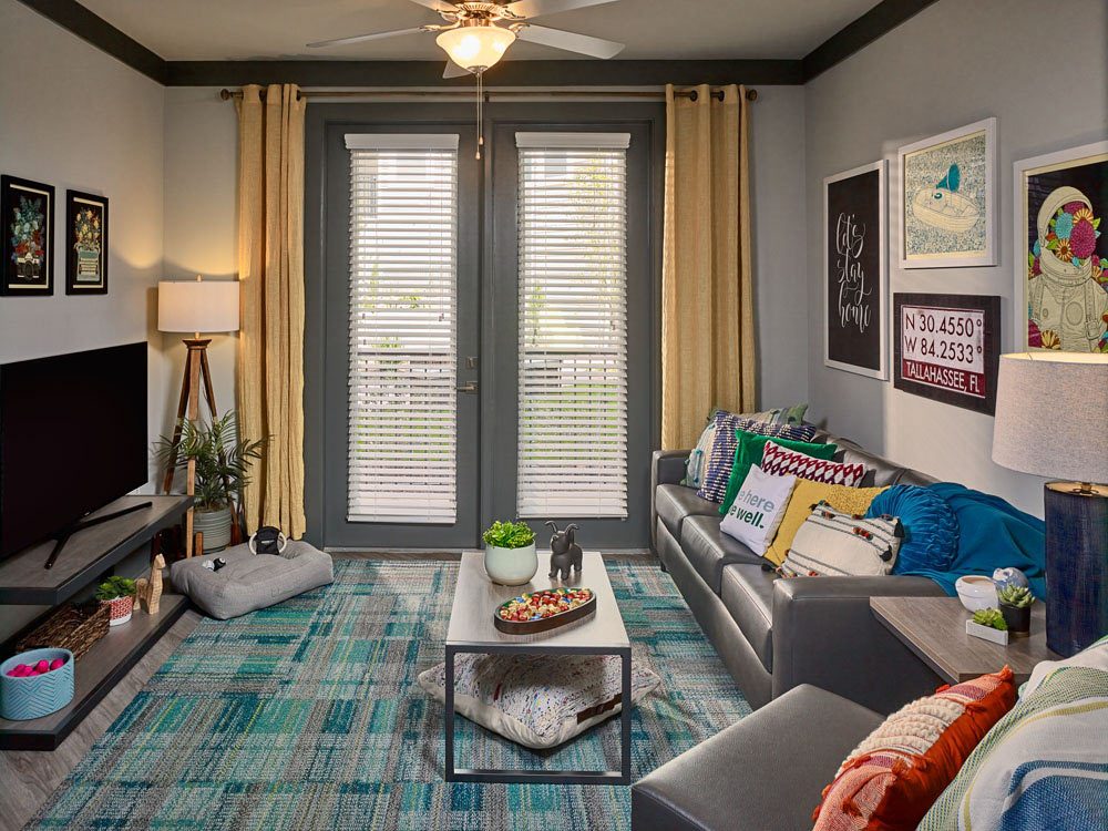 Reference photo of a 4x4 pod living room with sofa, art, and study area